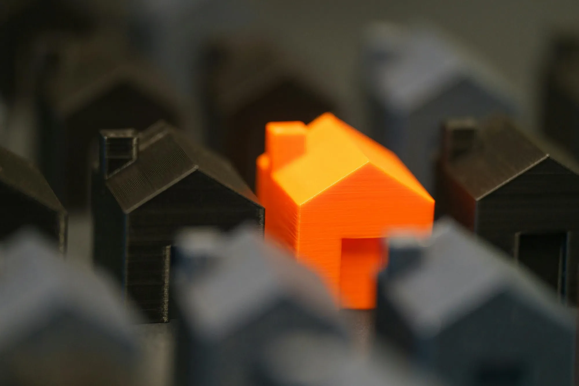Orange husmodell bland svarta – symboliserar fragmenterade system