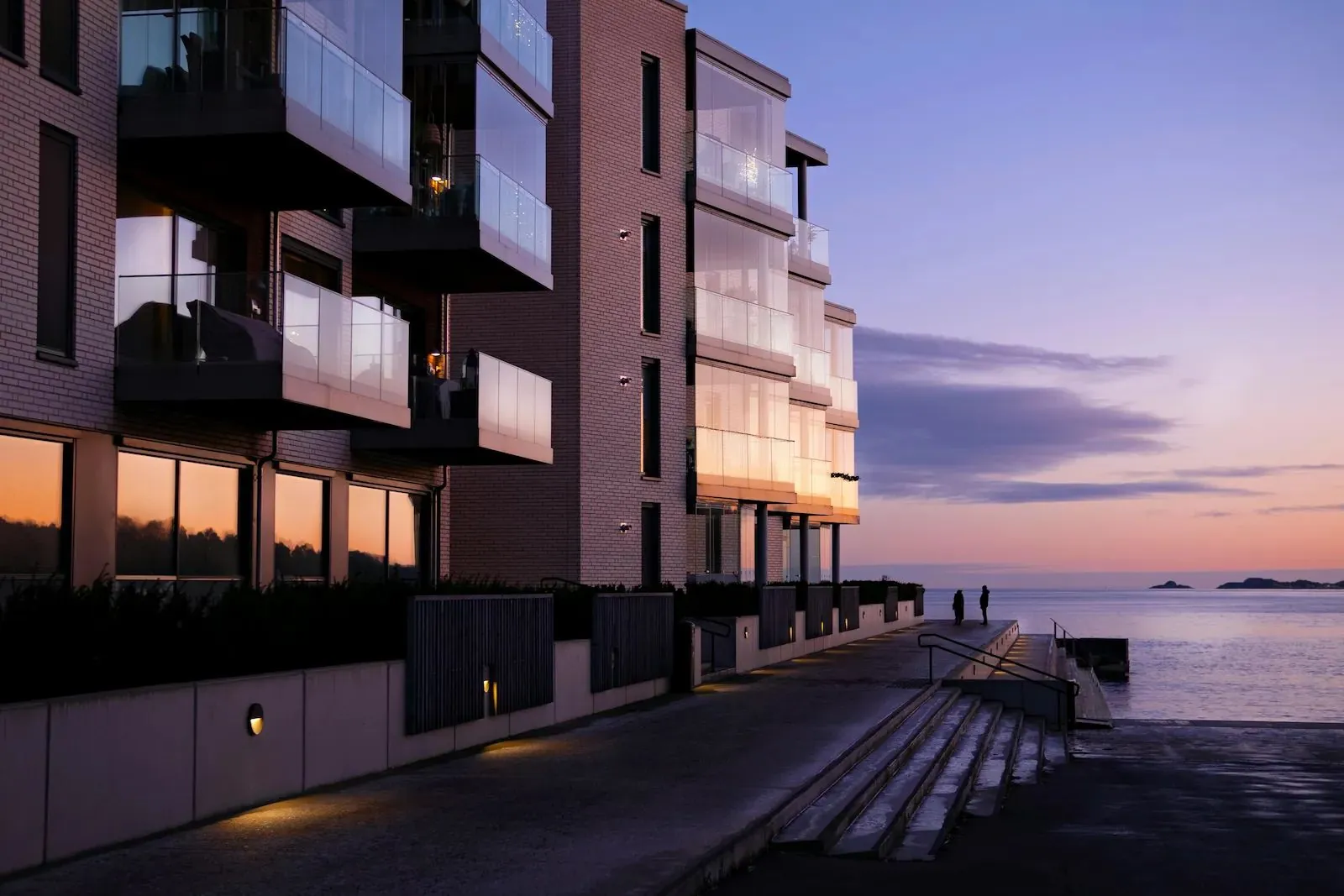Modern fastighetsbyggnad vid havet i solnedgång – Single Pane of Glass teknologi
